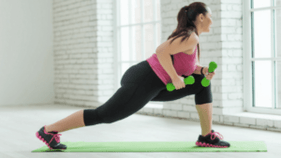 La fille effectue un exercice avec des haltères
